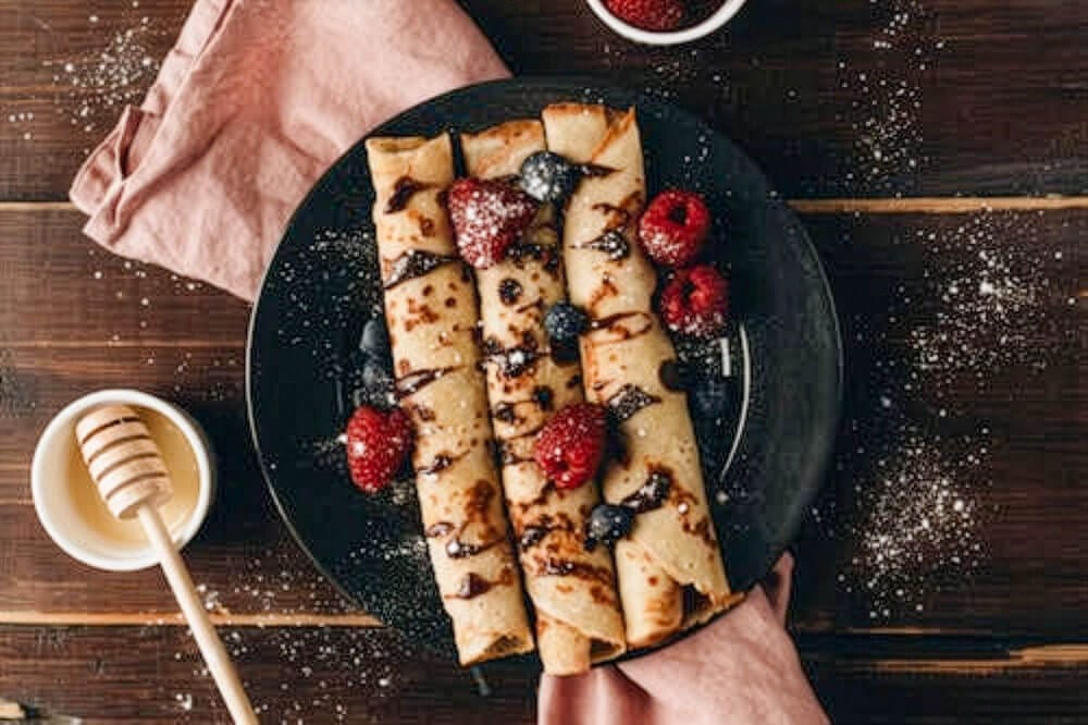 Bavarian Crepes on a plate with berries on top.