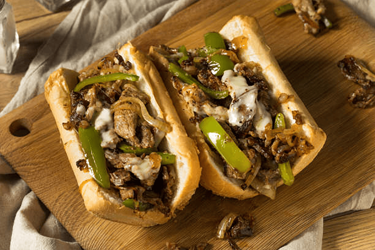 Cheesesteak cut in half on a table.
