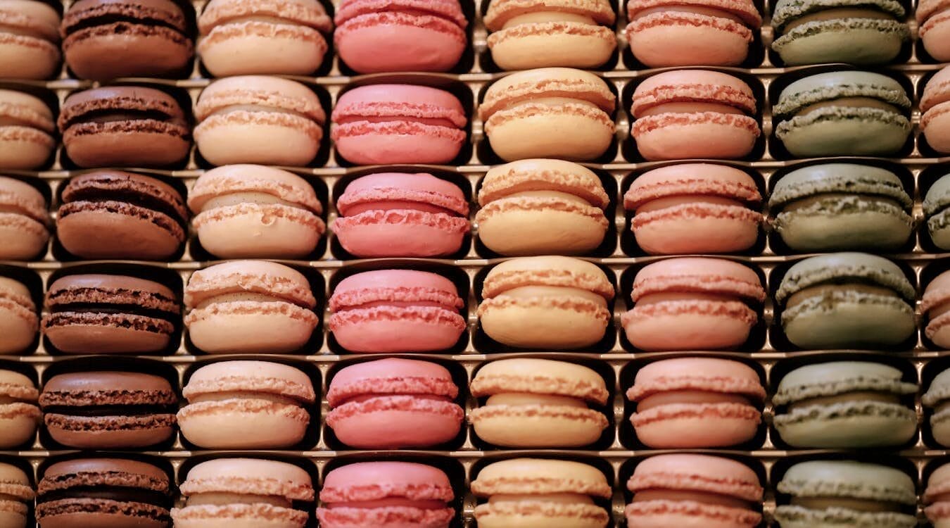 Multiple flavors of macaroons on a tray.