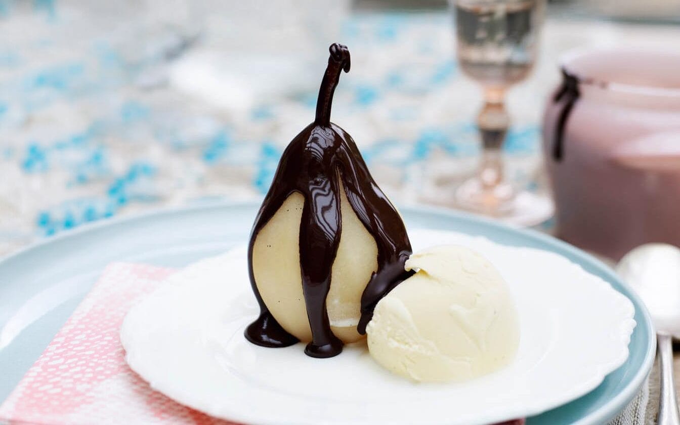 Pears Helene served on a plate with ice cream.