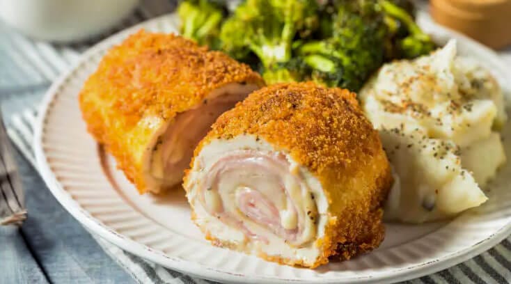 Cordon Bleu on a plate with vegetables and mashed potatoes